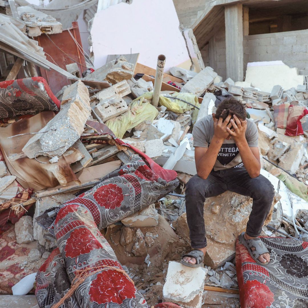 Child sitting in a pile of rubble in Palestine